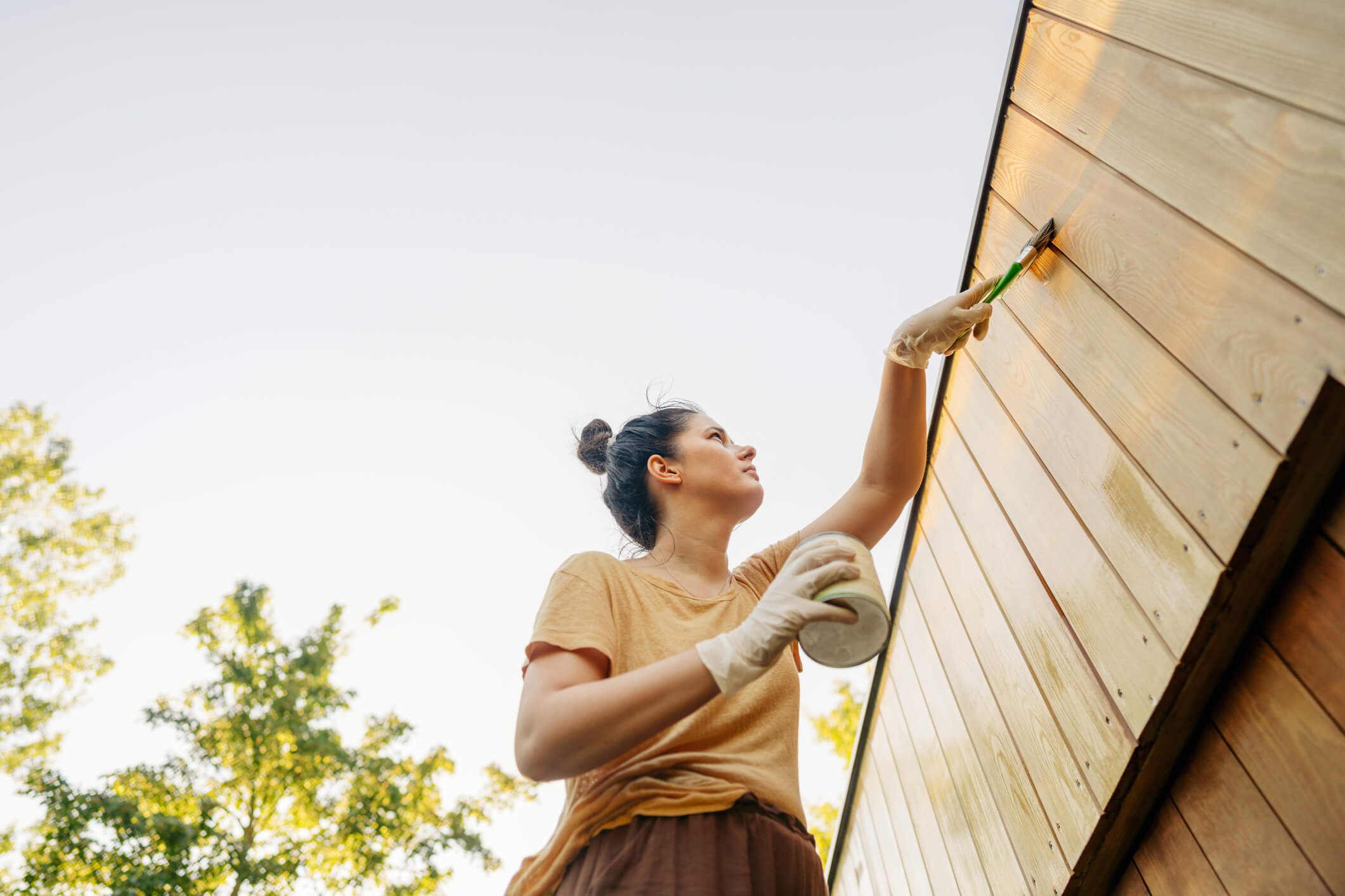 Person painting with brush outside